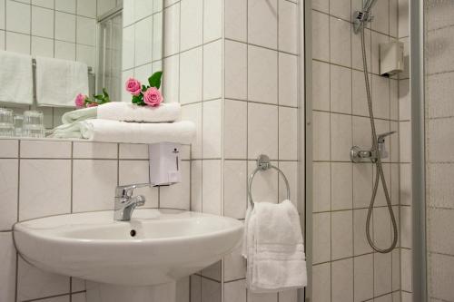 莱比锡阿斯特拉尔茵莱比锡酒店与餐厅的浴室配有盥洗盆、淋浴和毛巾