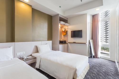 吉隆坡Scott Hotel KL Sentral的一间酒店客房,设有两张床和电视