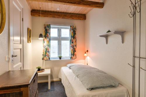 维堡Viborg City Rooms的一间卧室配有一张床、一张书桌和一个窗户。