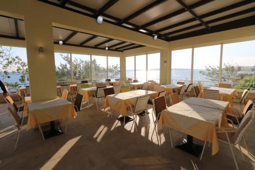拉扎纳茨Hotel Vila 4m的餐厅设有桌椅和窗户。