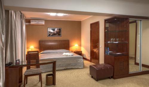 阿拉木图远航酒店的一间卧室配有一张床、一张桌子和一张桌子