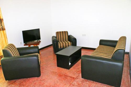 蒂瑟默哈拉默奢华生态丛林酒店的客厅配有椅子、桌子和电视