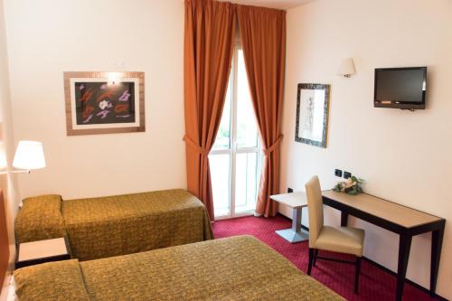 法塔特米Hotel Fontanelle的配有一张床和一张书桌的酒店客房