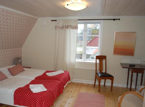 Kastlösa埃雷戈登凯斯特洛萨酒店的一间卧室配有一张床、一张桌子和一个窗户。