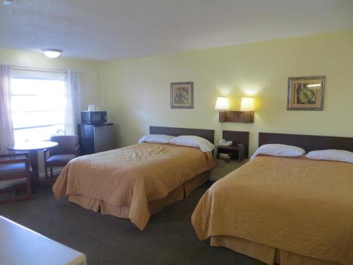 海恩斯城State Motel Haines City的酒店客房配有两张床和一张书桌