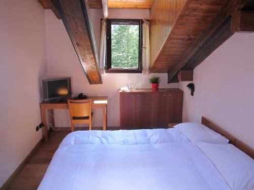 马库尼亚加高山唐古安尼娜酒店的一间卧室配有一张床、一张书桌和一个窗户。