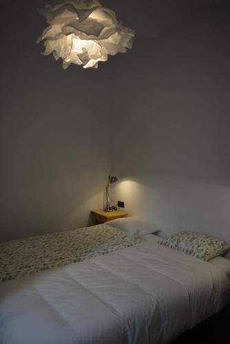 赫罗纳Nou del Teatre 20的卧室配有白色的床和吊灯。