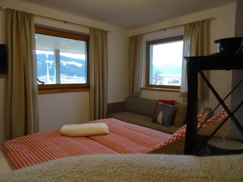 弗拉绍Appartement Hoamatgfühl的一间卧室配有一张床、一张沙发和两个窗户。