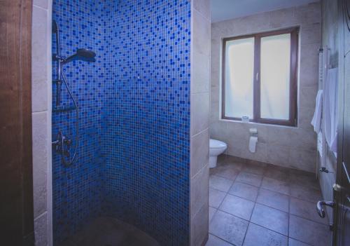 科布列季Marshal Resort Kobuleti的浴室设有蓝色瓷砖淋浴和卫生间