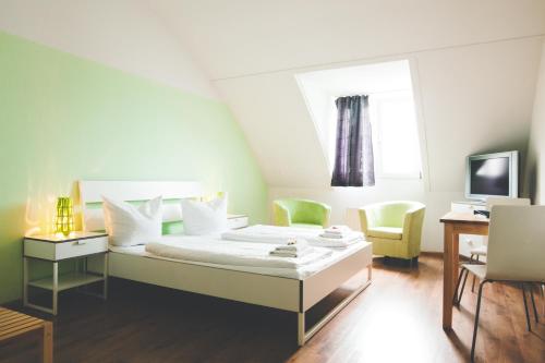 弗莱堡施泰因旅馆招待所的一间卧室配有一张床、两把椅子和电视