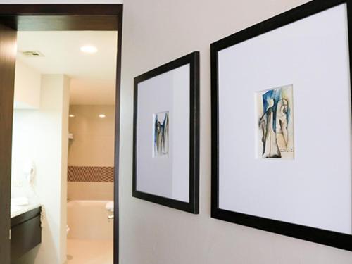 恩塞纳达港珊瑚码头酒店的浴室墙上挂着两张画框