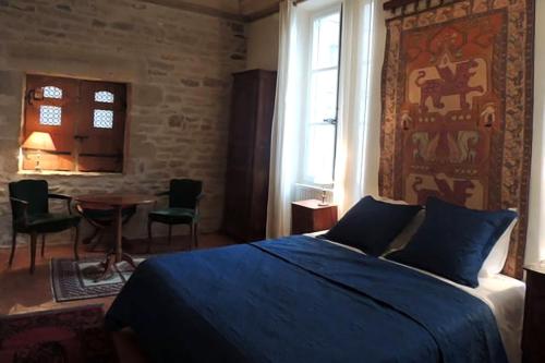 克卢尼Maison Romane 1136的一间卧室配有一张床和一张桌子及椅子