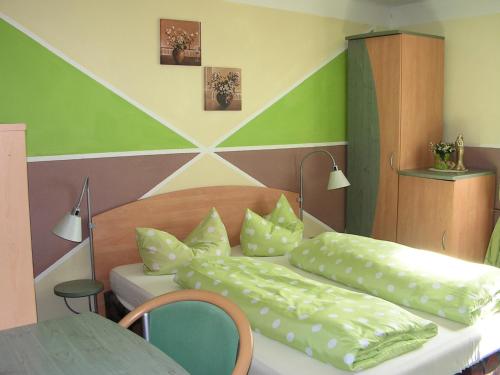 伦茨基希斯特恩酒店的一间卧室配有两张带枕头和桌子的床