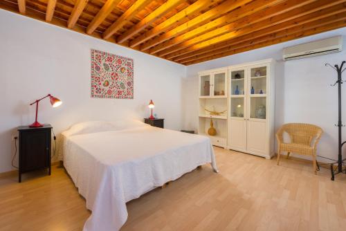 林都斯林都斯别墅度假屋的卧室设有白色的床和木制天花板。