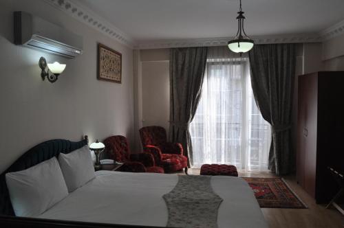 伊斯坦布尔巴赛勒斯酒店的一间卧室配有一张床、两把椅子和一个窗户