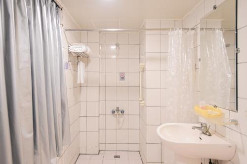 中坜伯爵商务旅店的带淋浴和盥洗盆的白色浴室