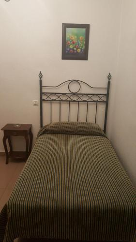 塞维利亚特拉哈诺旅馆的卧室里带条纹床罩的床