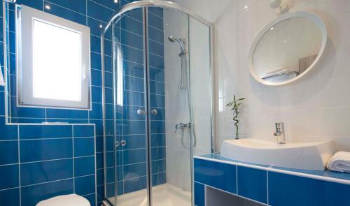 马卡尔斯卡Apartments Denis的蓝色和白色的浴室设有水槽和镜子