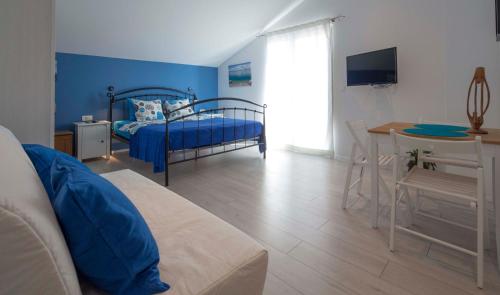 马卡尔斯卡Apartments Denis的蓝色的客房配有一张床、一张桌子和一张书桌