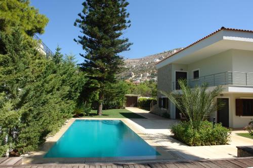 萨罗尼扎Villa Saronida的房屋前的游泳池