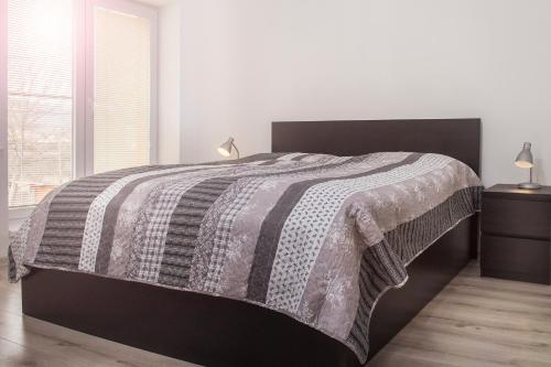 普雷绍夫Garden apartments的一间卧室配有一张带黑白毯子的床