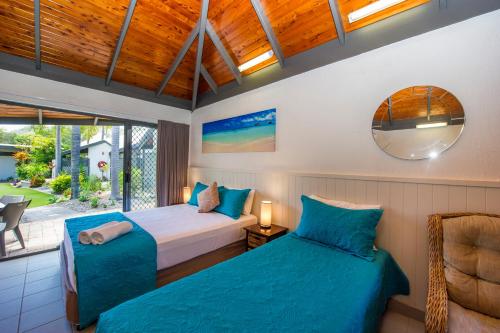 耐莉湾岛屿休闲度假酒店的带窗户的客房内的两张床