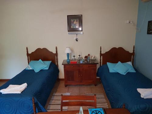 Santa RosaLoft en Casona Colonial的配有两张床铺、蓝色床单和一张桌子的客房