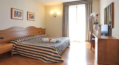 圣奇诺·迪·蒙塔尼亚科斯塔贝拉酒店的酒店客房,配有床和电视