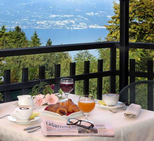 圣奇诺·迪·蒙塔尼亚科斯塔贝拉酒店的阳台上配有带酒杯和食物的桌子