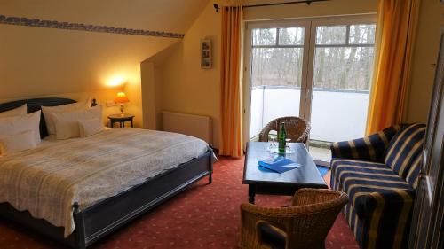 施特拉尔松德库热翰斯德文酒店的一间卧室配有一张床、一张桌子和一张沙发