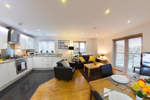 博勒姆伍德Borehamwood - Spacious Apartment的厨房以及带沙发和桌子的客厅。