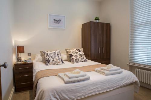亨顿Finchley Central Spacious 3 bed triplex loft style apartment的一间卧室配有两张带毛巾的床