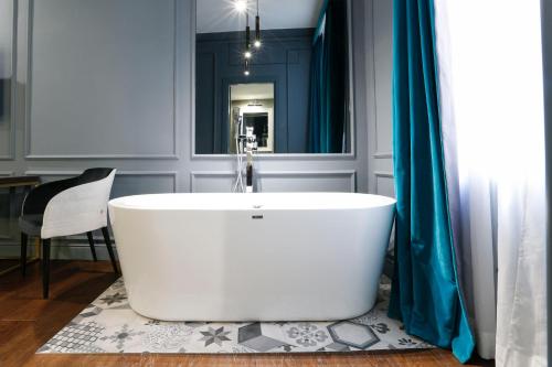 罗马圣B精品STB酒店的浴室设有白色浴缸及镜子