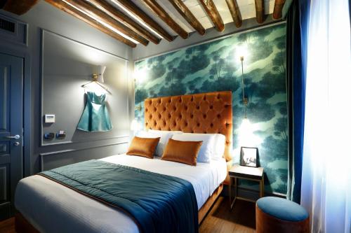 罗马圣B精品STB酒店的卧室配有一张床,墙上挂有绘画作品