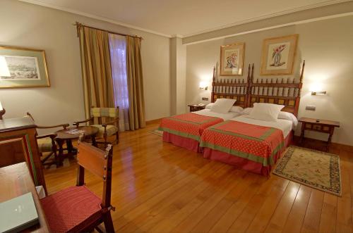 卡拉奥拉帕拉多卡拉霍拉酒店的酒店客房带两张床和一张桌子以及椅子。