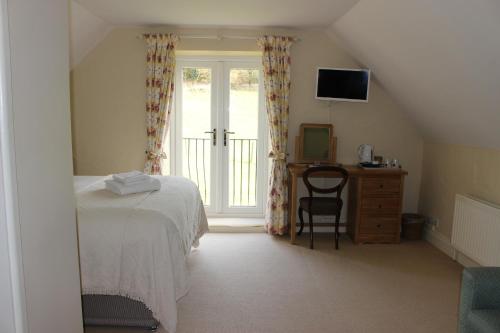 卡恩The White Horse Inn的一间卧室配有一张床、一张书桌和一个窗户。