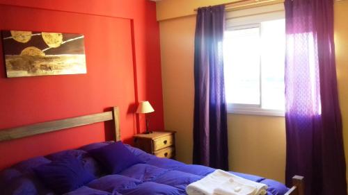 科尔多瓦Temporario en Villa Sol的一间卧室配有一张床和一个带紫色窗帘的窗户