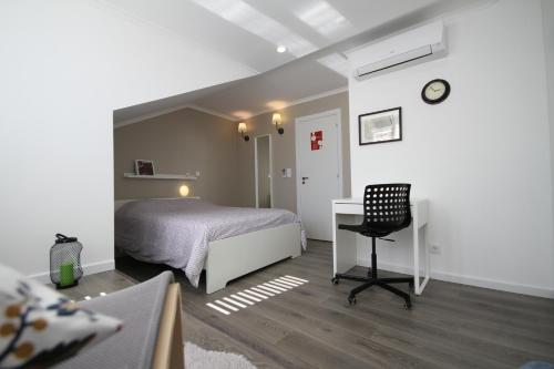 里斯本阿尔法玛右点公寓的一间卧室配有一张床、一张桌子和一把椅子