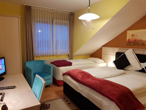 比伯斯海姆飞天大酒店 的酒店客房,配有两张床和椅子