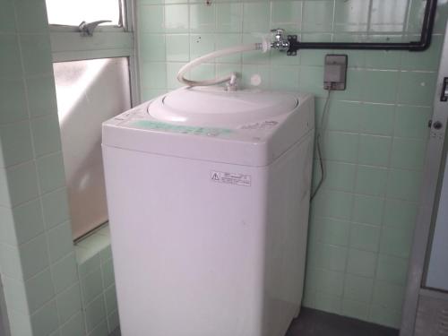 石垣岛碧海白保之宿旅馆的一间带盥洗盆的浴室内的洗衣机