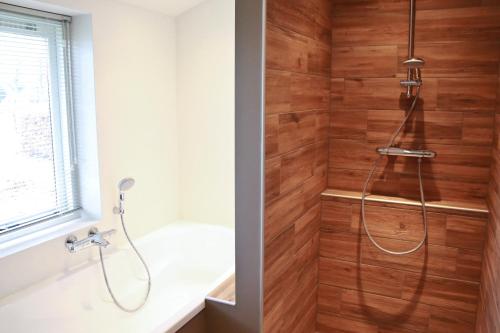 Den DungenResidentie De Hoek的带淋浴的浴室和木墙