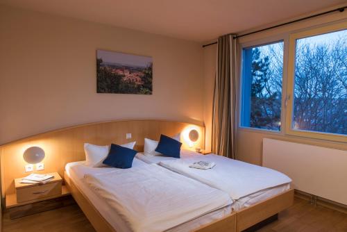 奎德林堡哈茨家庭俱乐部假日公园的一间卧室配有一张带蓝色枕头的大床
