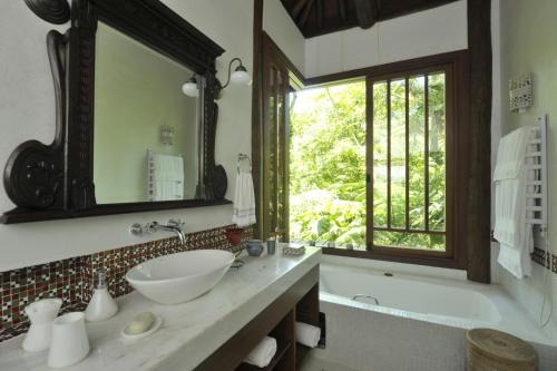 坎布里Casa Sertão de Camburi的一间带水槽和浴缸的浴室以及窗户。