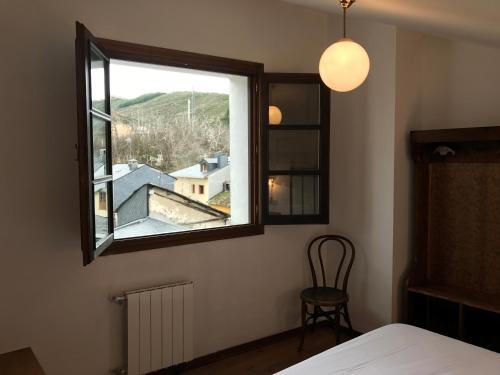 莫利纳塞卡La Casa Del Reloj的卧室设有窗户、椅子和桌子