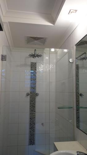 达尔文巴厘一室公寓的一间带玻璃淋浴和吊扇的浴室