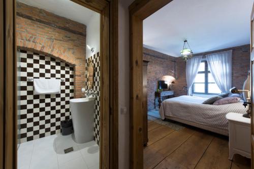 布拉索夫Casa Veche的一间带砖墙和床的卧室以及一间浴室