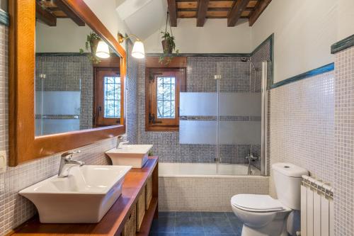 拉阿贝尔卡El Aserradero的浴室配有2个盥洗盆、卫生间和浴缸。