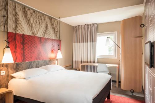 贝桑松宜必思贝桑松中心威乐酒店的酒店客房,设有白色的床和红色的墙壁