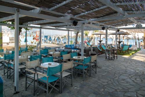 毕达哥利翁Studio Nikos的庭院里设有蓝色椅子和桌子的餐厅