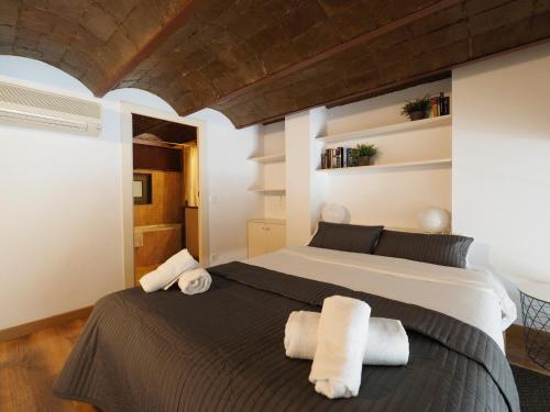 巴塞罗那格拉西亚大道设计公寓的一间卧室配有一张大床和毛巾